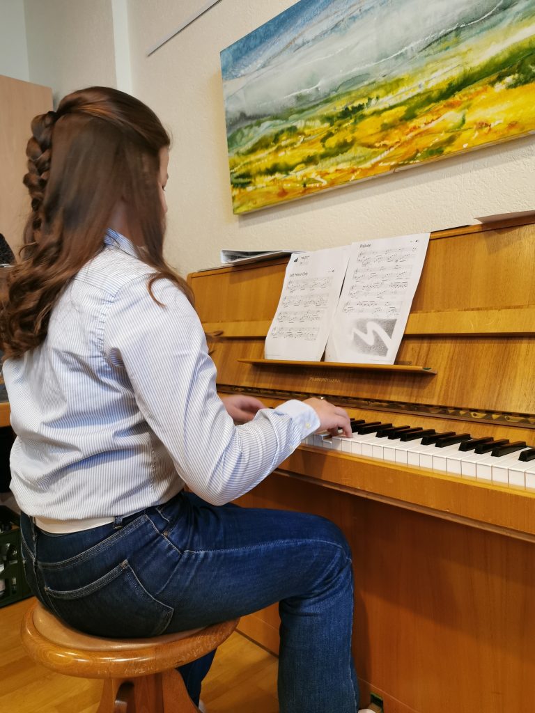 Musikalische Umrahmung der Eröffnungsfeier - das Bild zeigt eine Frau, die Klavier spielt